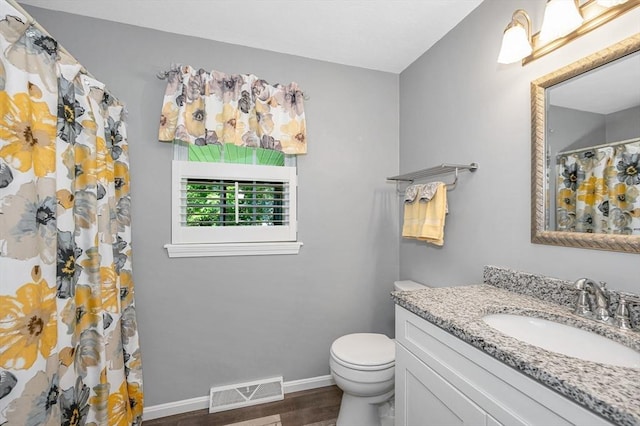 218 Acropolis Rd, Lowell, MA 01854 - full bathroom with wood finished floors, vanity, toilet, baseboards, and a shower with shower curtain