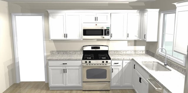 kitchen with appliances with stainless steel finishes, light stone counters, sink, white cabinets, and light hardwood / wood-style floors