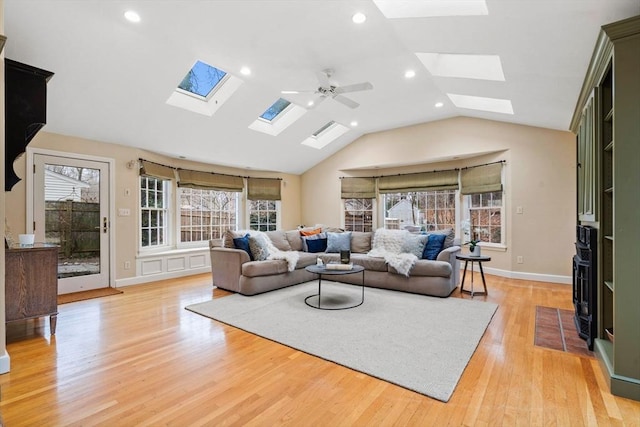 living room featuring ceiling fan, lofted ceiling, and light hardwood / wood-style flooring