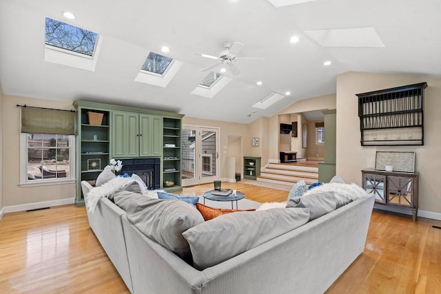 living room featuring light hardwood / wood-style flooring, vaulted ceiling, and ceiling fan