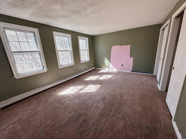 unfurnished bedroom featuring baseboards, carpet floors, baseboard heating, and a textured ceiling