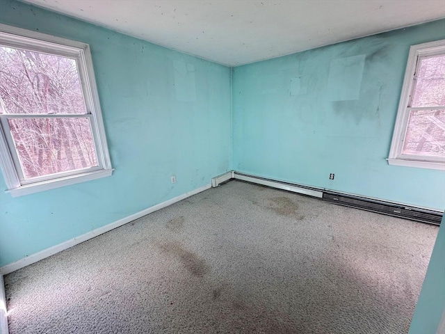 carpeted empty room featuring baseboards and baseboard heating