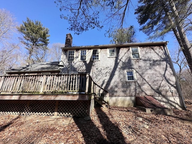 back of property with a chimney and a wooden deck