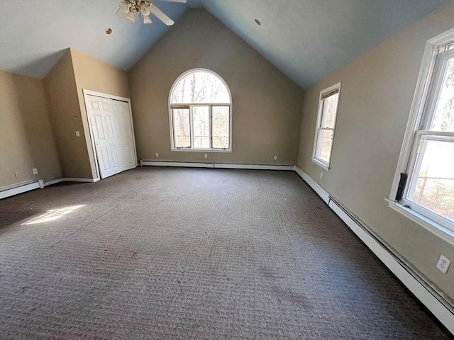 unfurnished bedroom featuring a baseboard heating unit, baseboards, high vaulted ceiling, and carpet flooring