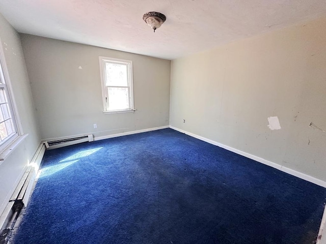 empty room with baseboard heating, a baseboard heating unit, baseboards, and dark colored carpet