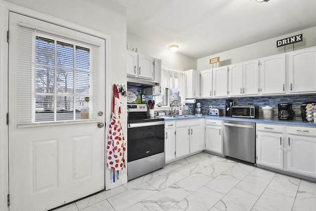 kitchen featuring appliances with stainless steel finishes, sink, decorative backsplash, and white cabinets