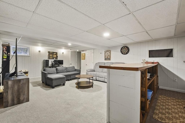 living room featuring dark colored carpet and a drop ceiling