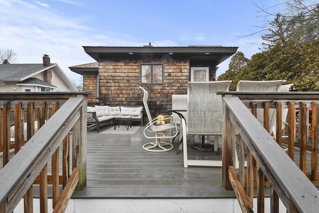 wooden terrace with an outdoor living space