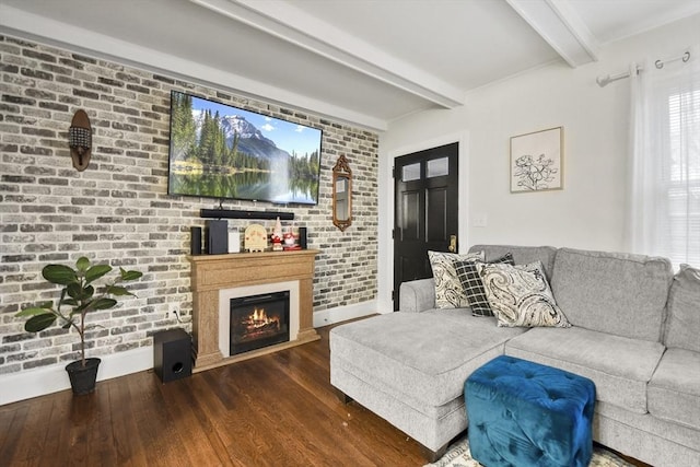 living room featuring dark hardwood / wood-style floors, brick wall, and beam ceiling