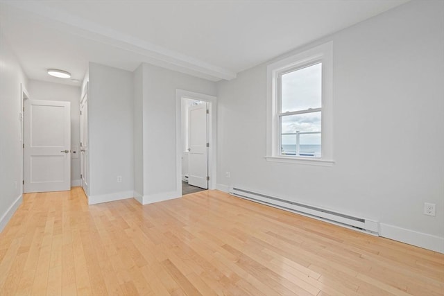 spare room featuring light wood-type flooring and a baseboard heating unit