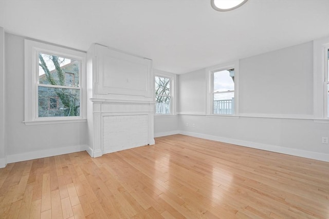 spare room featuring a healthy amount of sunlight and light hardwood / wood-style floors