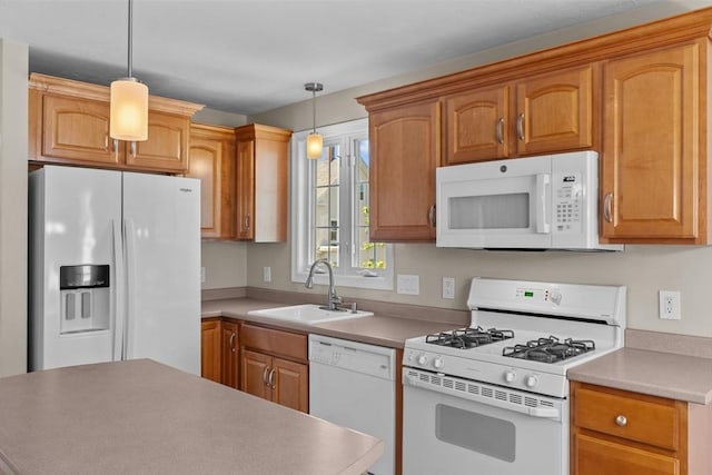 kitchen featuring white appliances, decorative light fixtures, a sink, and light countertops
