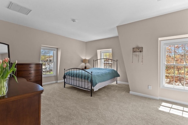 bedroom featuring visible vents, light carpet, and multiple windows