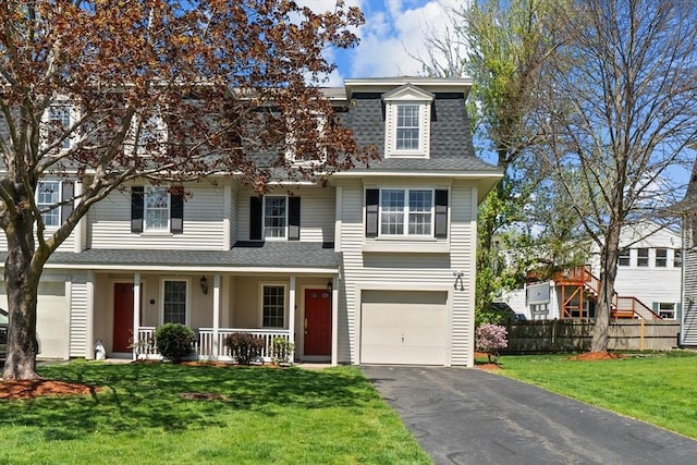 view of front of property featuring roof with shingles, fence, a front lawn, aphalt driveway, and covered porch