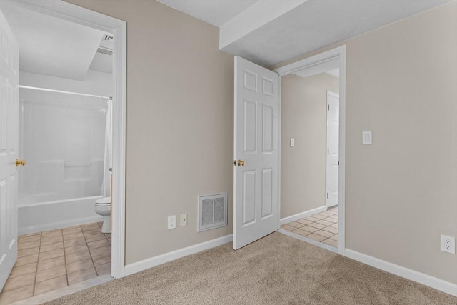 unfurnished bedroom with tile patterned floors, baseboards, carpet floors, and visible vents
