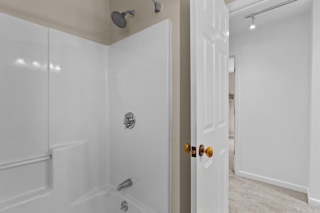 bathroom featuring baseboards and bathtub / shower combination