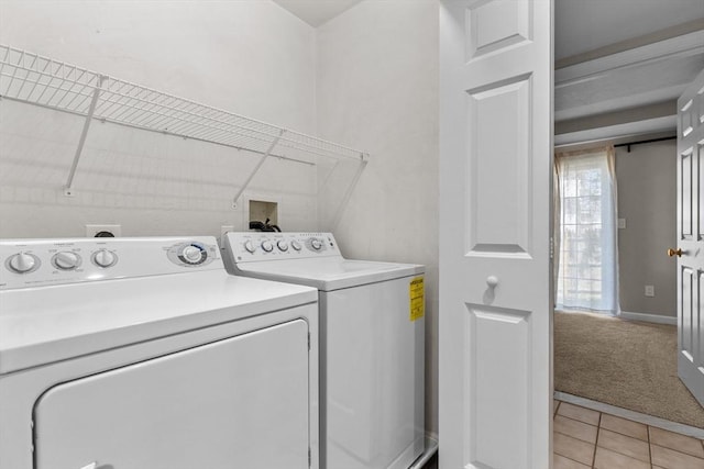 laundry area featuring laundry area, light carpet, separate washer and dryer, baseboards, and light tile patterned floors