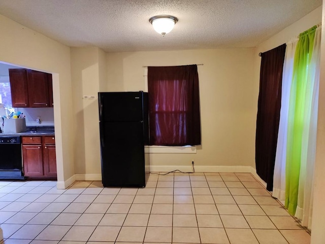 kitchen with light tile patterned floors, black appliances, and a textured ceiling