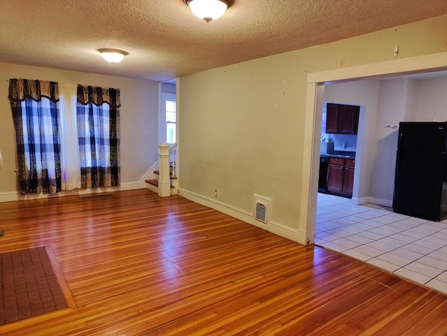 empty room featuring a textured ceiling and light wood-type flooring