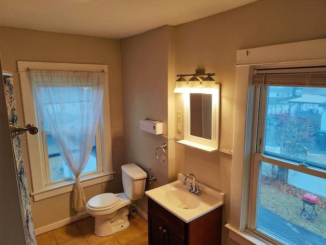 bathroom with toilet, vanity, and tile patterned floors