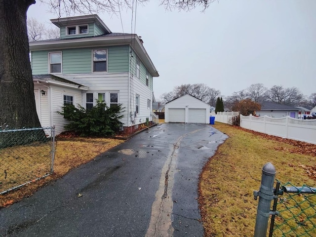 view of front facade with a garage, an outbuilding, and a front lawn