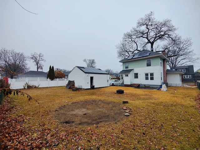 back of house with an outbuilding and a yard