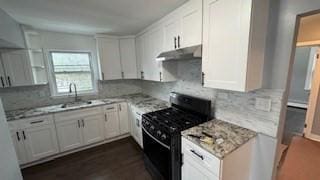 15 York St, Haverhill, MA 01830 - kitchen with black gas range, under cabinet range hood, tasteful backsplash, and white cabinetry