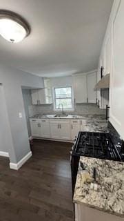 15 York St, Haverhill, MA 01830 - kitchen featuring baseboards, dark wood-type flooring, white cabinets, a sink, and under cabinet range hood