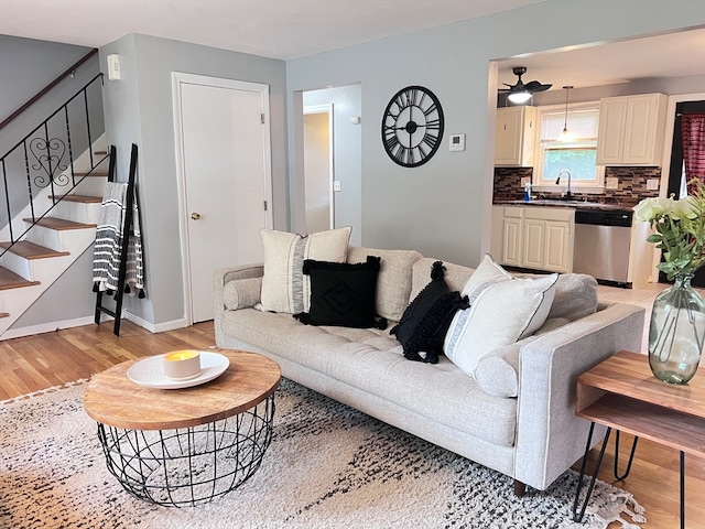 living room with light hardwood / wood-style floors and sink