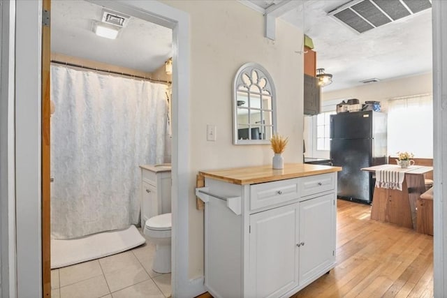 full bath with visible vents, toilet, vanity, and hardwood / wood-style flooring