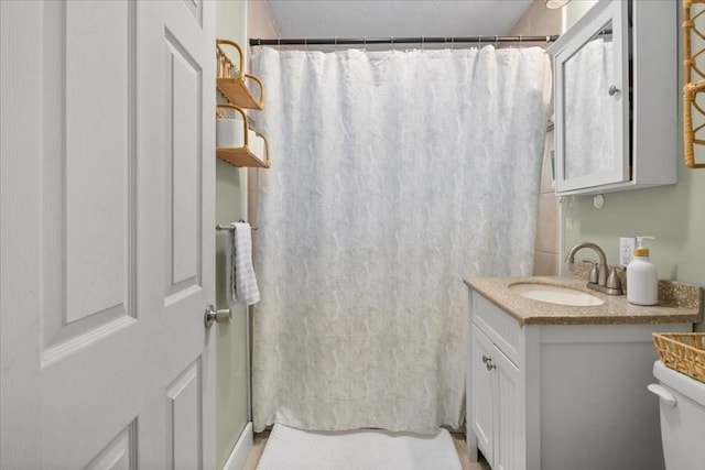 bathroom with vanity, a shower with shower curtain, and toilet