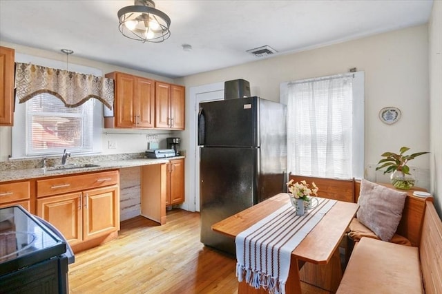 kitchen with black appliances, a healthy amount of sunlight, visible vents, and a sink