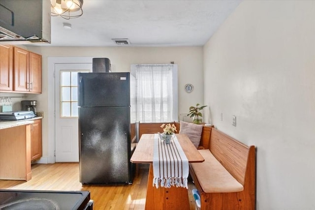 dining room with breakfast area, visible vents, and light wood-type flooring