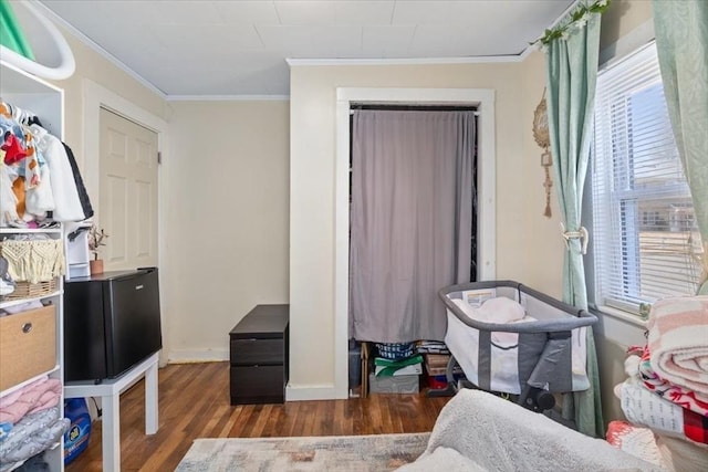 bedroom with baseboards, wood finished floors, and ornamental molding