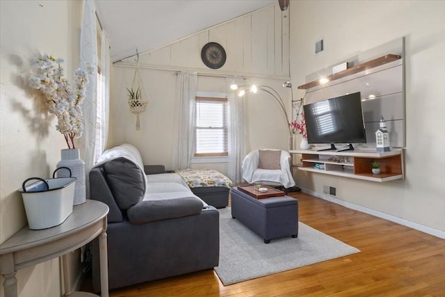 living room featuring visible vents, high vaulted ceiling, light wood-type flooring, and baseboards