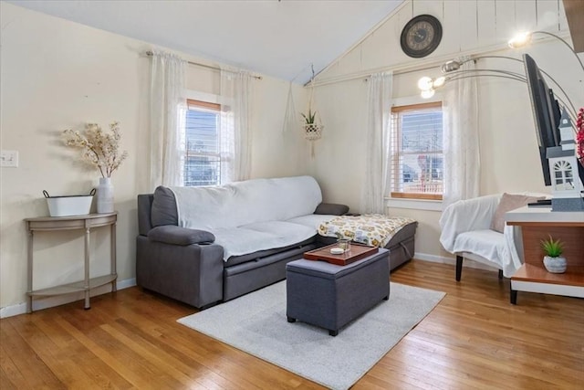 living room with plenty of natural light, baseboards, lofted ceiling, and wood-type flooring