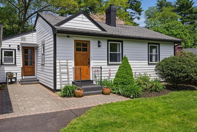 13 Kingston St, North Reading, MA 01864 - view of front of house with a chimney, entry steps, a shingled roof, and a front yard