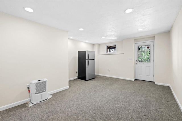 basement featuring baseboards, freestanding refrigerator, carpet flooring, and recessed lighting