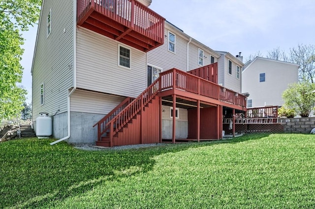 back of property featuring a lawn, a wooden deck, and stairs