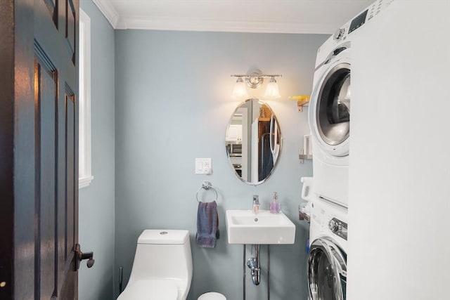 114 Tudor St, Boston, MA 02127 - bathroom featuring estacked washer and dryer, toilet, crown molding, and a sink