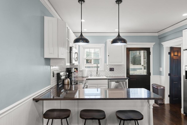 114 Tudor St, Boston, MA 02127 - kitchen with appliances with stainless steel finishes, a sink, wainscoting, plenty of natural light, and a peninsula