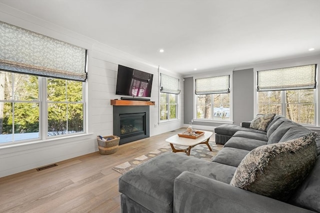 living room with light hardwood / wood-style floors and a large fireplace