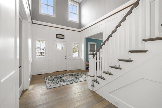 entryway with wood-type flooring and a high ceiling