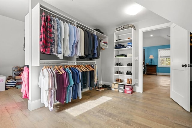 walk in closet with wood-type flooring and lofted ceiling