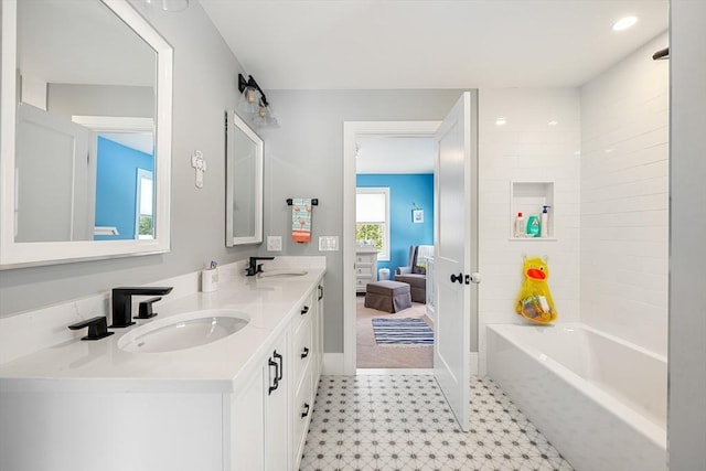 bathroom with tiled shower / bath combo and vanity