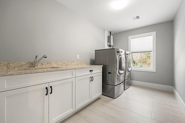 laundry room featuring cabinets, sink, and washing machine and clothes dryer