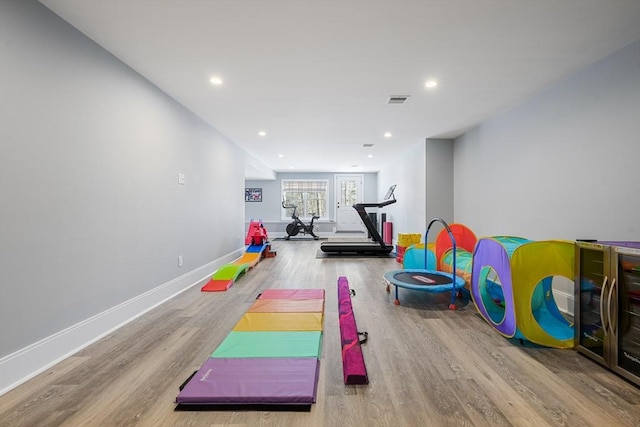 exercise room with light hardwood / wood-style floors