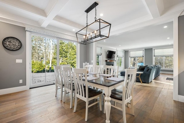 dining room with coffered ceiling, hardwood / wood-style floors, and beamed ceiling