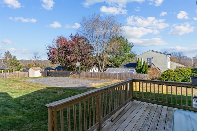 wooden terrace featuring a yard and a shed