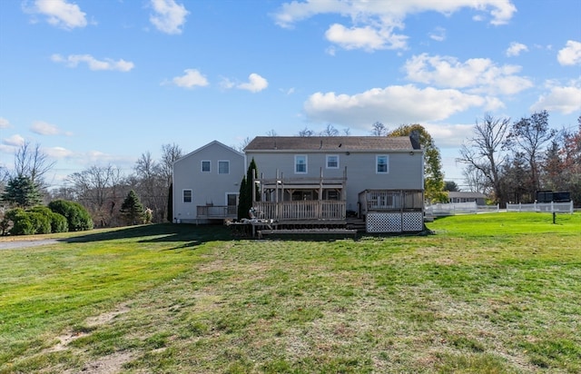 rear view of house with a yard, a deck, and a sunroom